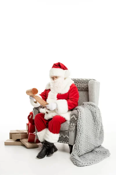 Santa Claus reading Christmas wishlist — Stock Photo