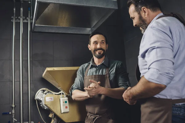 Male brewery workers in aprons — Stock Photo