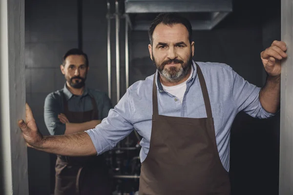 Male brewery workers in aprons — Stock Photo