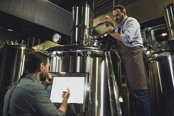 Brewers working with tanks — Stock Photo