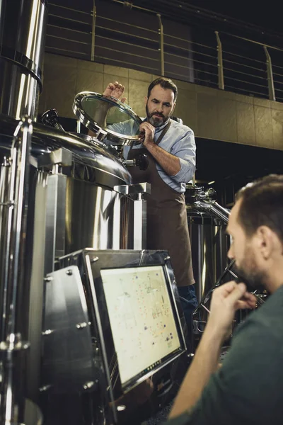 Cerveceros que trabajan con tanques - foto de stock