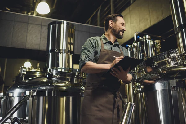 Worker inspecting equipment at brewery — Stock Photo