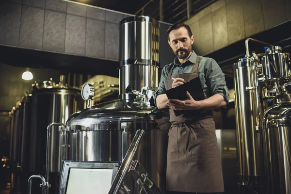 Worker inspecting equipment at brewery — Stock Photo