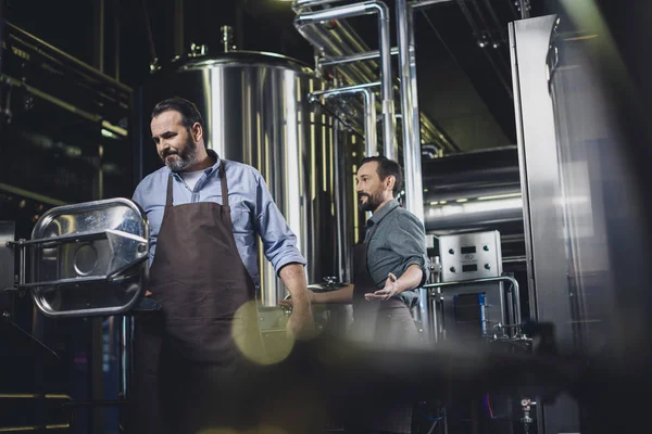 Cervejarias trabalhando com equipamentos industriais — Fotografia de Stock