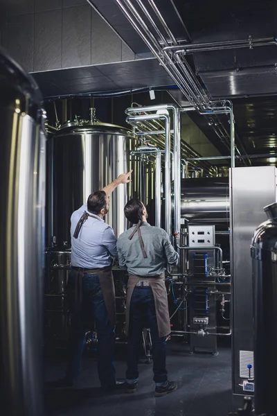 Brewers working with industrial equipment — Stock Photo