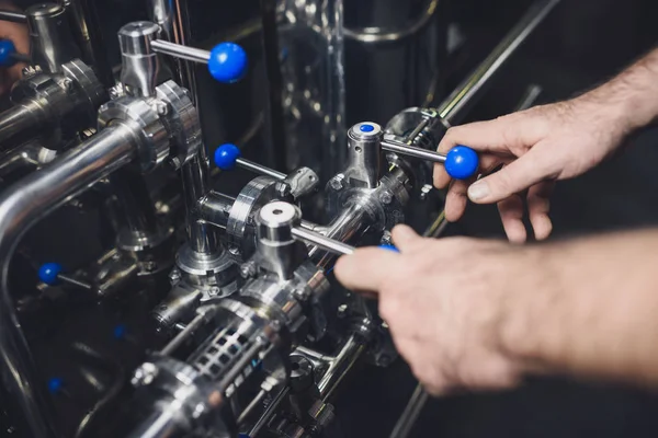 Cervecera que trabaja con equipos industriales - foto de stock