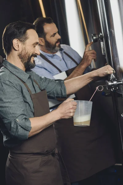 Brewery worker pouring beer — Stock Photo