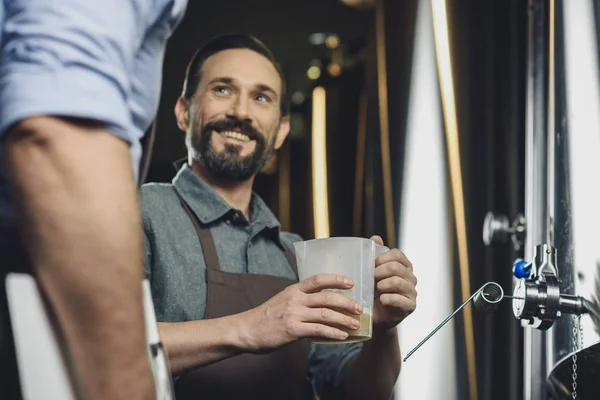 Cervecero sosteniendo jarra con cerveza - foto de stock