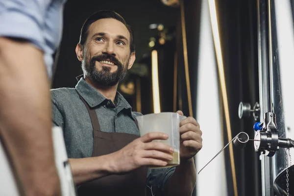 Cervecero sosteniendo jarra con cerveza - foto de stock