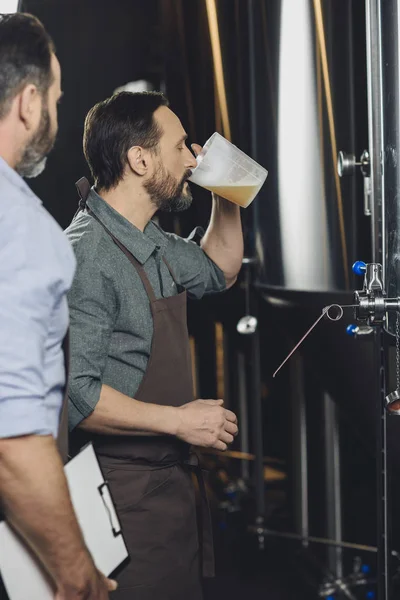 Cervejeiro segurando jarro com cerveja — Fotografia de Stock