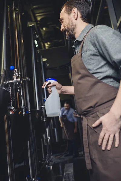 Worker cleaning brewery equipment — Stock Photo