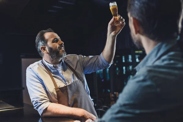 Trabajador cervecero con vaso de cerveza - foto de stock