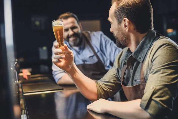 Lavoratore birreria con bicchiere di birra — Foto stock