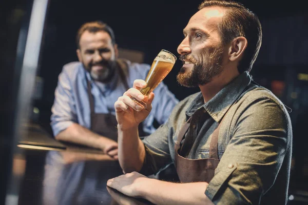 Brewery worker with glass of beer — Stock Photo