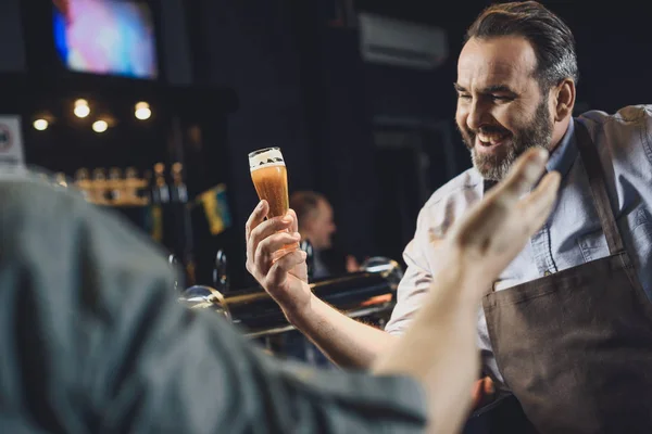 Trabajador cervecero con vaso de cerveza - foto de stock