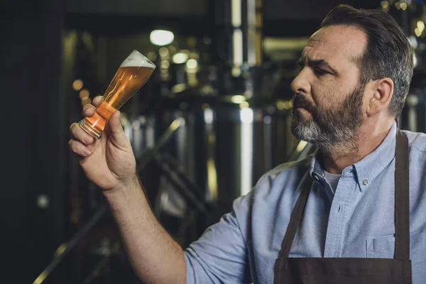 Trabalhador da cervejaria com copo de cerveja — Fotografia de Stock