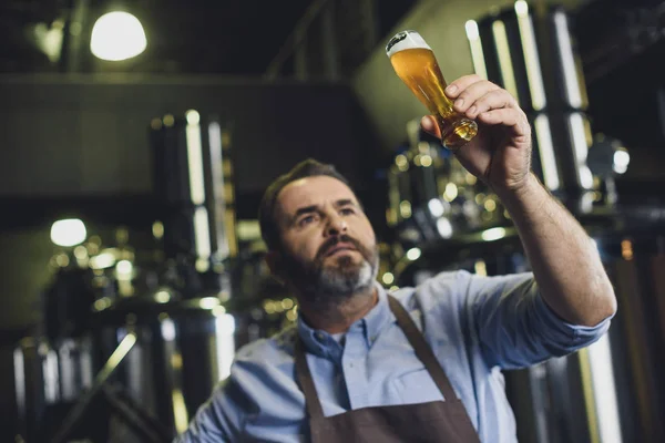 Ouvrier de brasserie avec verre de bière — Photo de stock