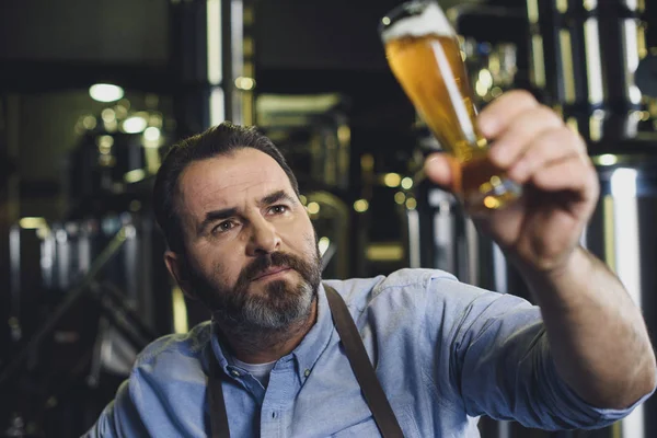 Ouvrier de brasserie avec verre de bière — Photo de stock