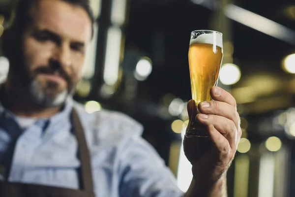 Trabajador cervecero con vaso de cerveza - foto de stock