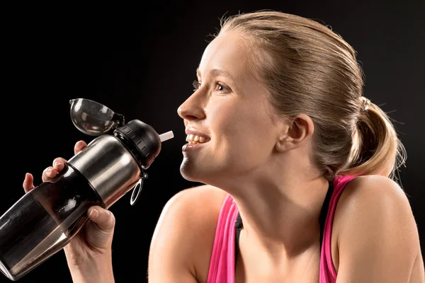 Sportswoman drinking water — Stock Photo