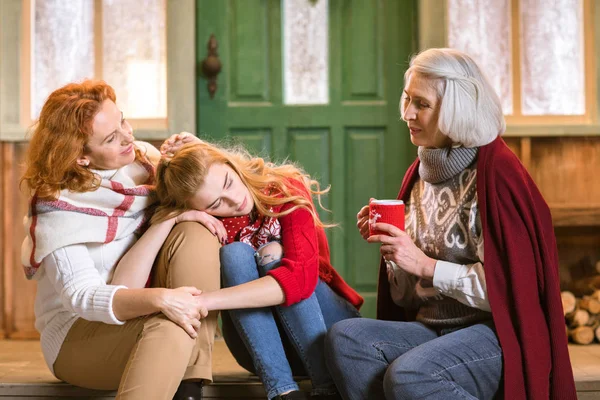 Family drinking hot tea on stairs — Stock Photo