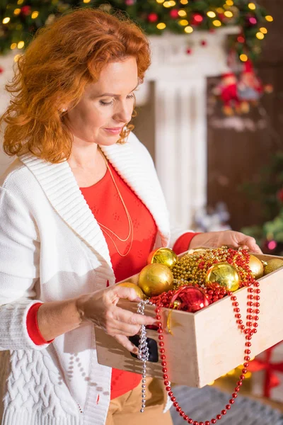 Woman holding box with baubles — Stock Photo