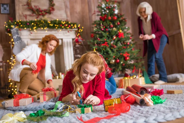 Girl wrapping gift box — Stock Photo