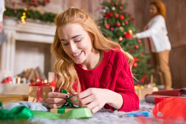 Girl wrapping gift box — Stock Photo