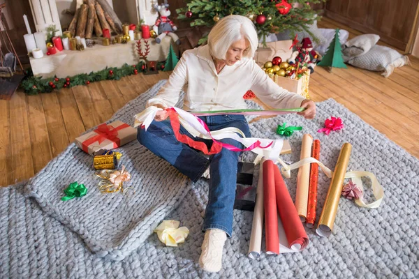 Femme enveloppant cadeaux de Noël — Photo de stock