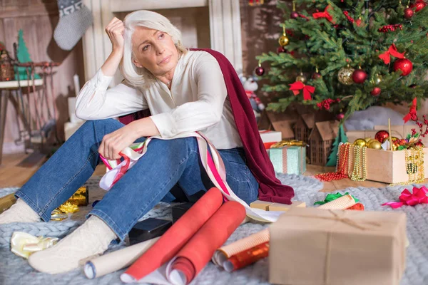 Thoughtful senior woman with gift boxes — Stock Photo
