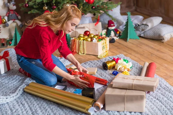 Girl wrapping gift boxes — Stock Photo