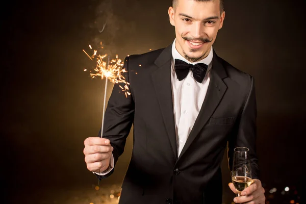 Handsome man holding sparkler — Stock Photo