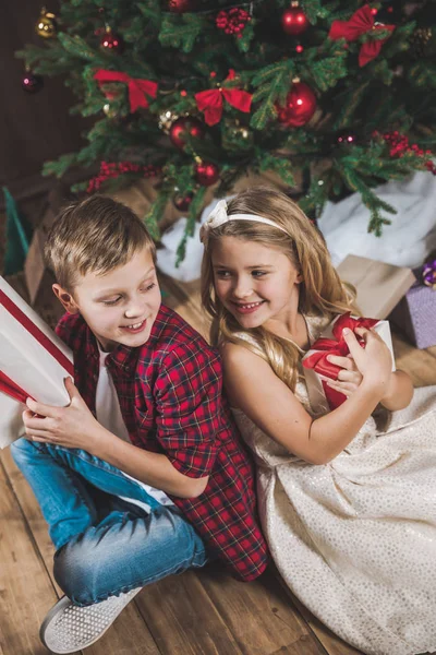 Hermanos sosteniendo cajas de regalo - foto de stock