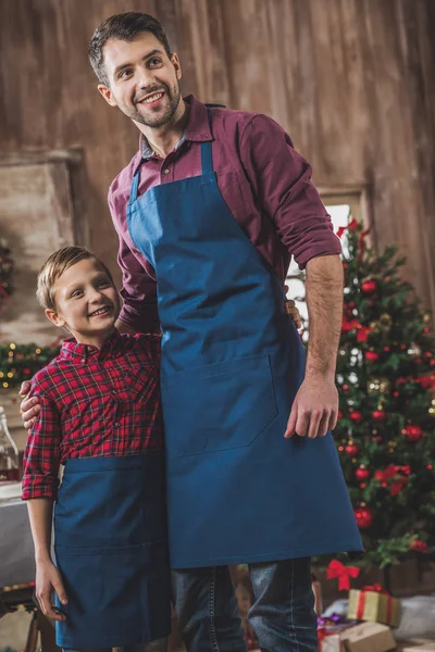 Padre e hijo en delantales azules - foto de stock