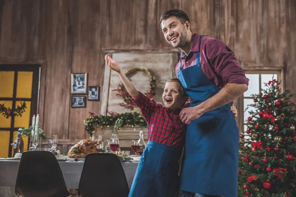 Padre e hijo en delantales azules - foto de stock