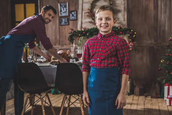 Niño feliz cerca de la mesa de Navidad - foto de stock