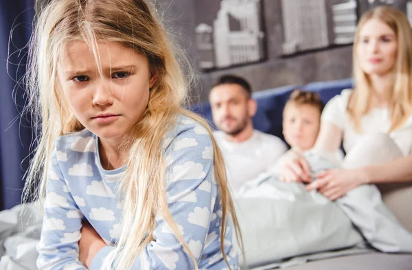 Little girl sitting on bed — Stock Photo