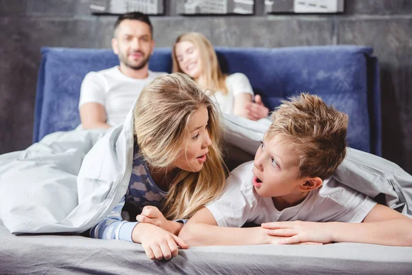 Happy siblings under duvet — Stock Photo