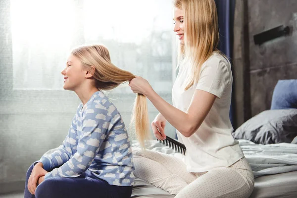 Mother combing hair of daughter — Stock Photo