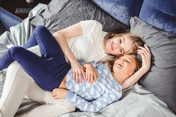 Счастливая мать и дочь в постели — стоковое фото