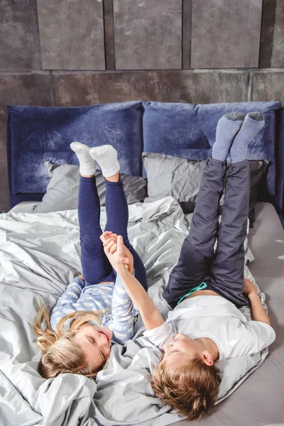Geschwister spielen im Bett — Stockfoto