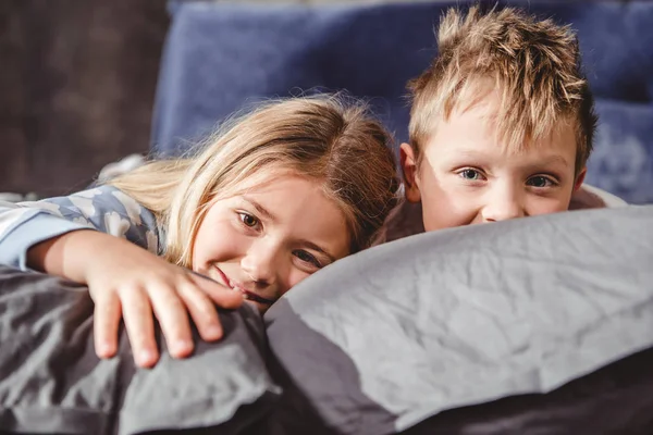 Bruder und Schwester liegen auf Kissen — Stockfoto