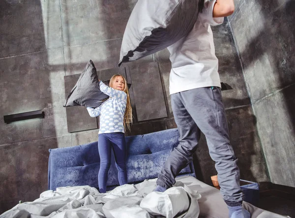 Hermanos luchando con almohadas - foto de stock