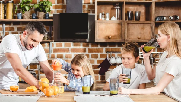 Family makes orange juice — Stock Photo