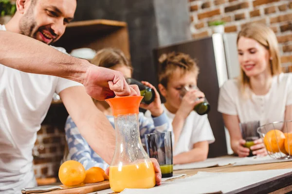 Homem faz suco de laranja — Fotografia de Stock