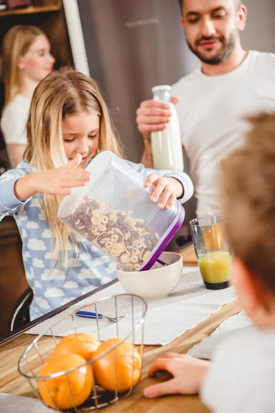 Mädchen gießt Kornflockenringe — Stockfoto