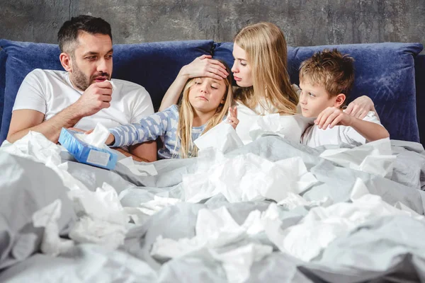 Famille malade au lit — Photo de stock