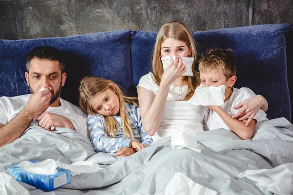 Famille malade au lit — Photo de stock