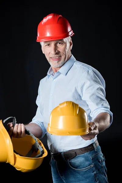 Homem segurando chapéus duros — Fotografia de Stock