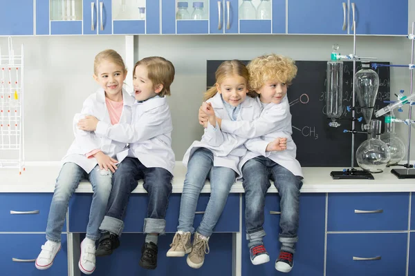 Schoolchildren sitting in laboratory — Stock Photo